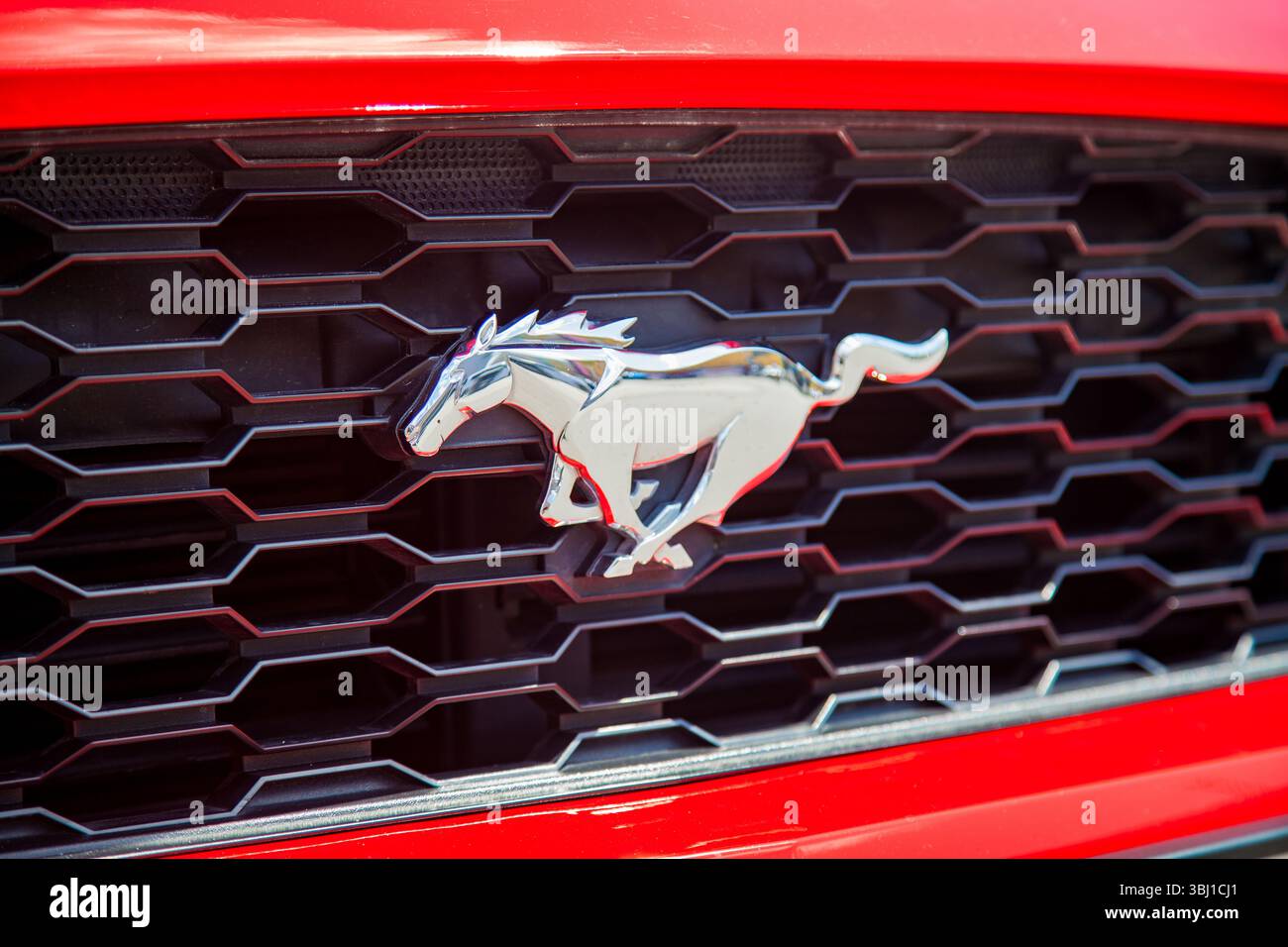 Vilnius, Litauen - 31-05-2025: Ford Mustang-Logo in Form eines silbernen Pferdes auf dem Kühlergrill eines roten Autos Stockfoto