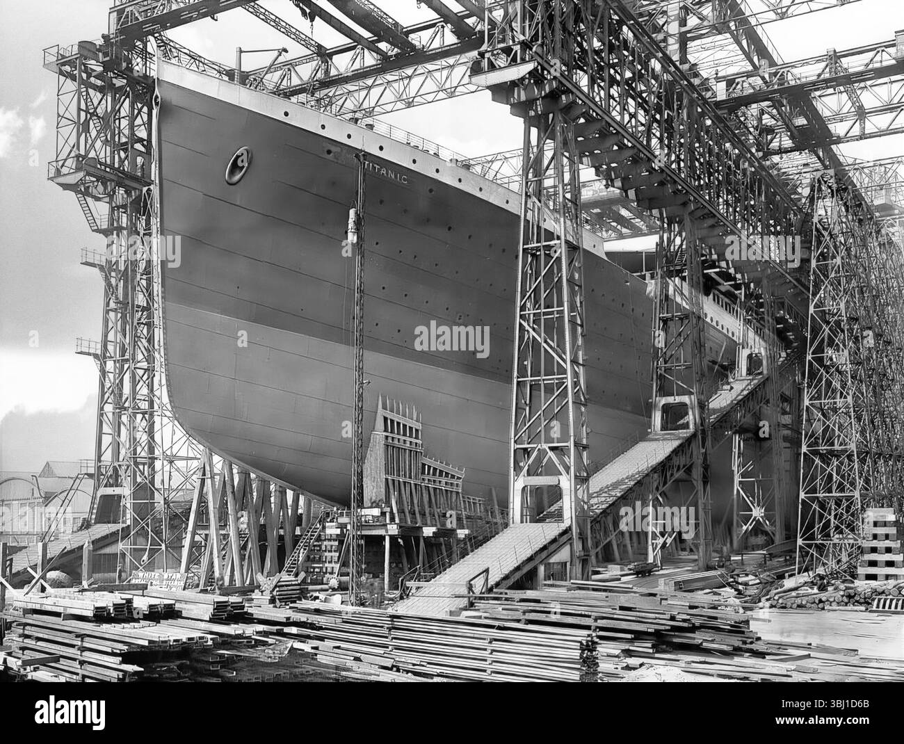 Eine Fotografie aus dem frühen 20. Jahrhundert in Belfasts Harland and Wolfe Werft in Nordirland des Bugs der Titanic während des Baus und umgeben von Schiffsbauteilen. Stockfoto