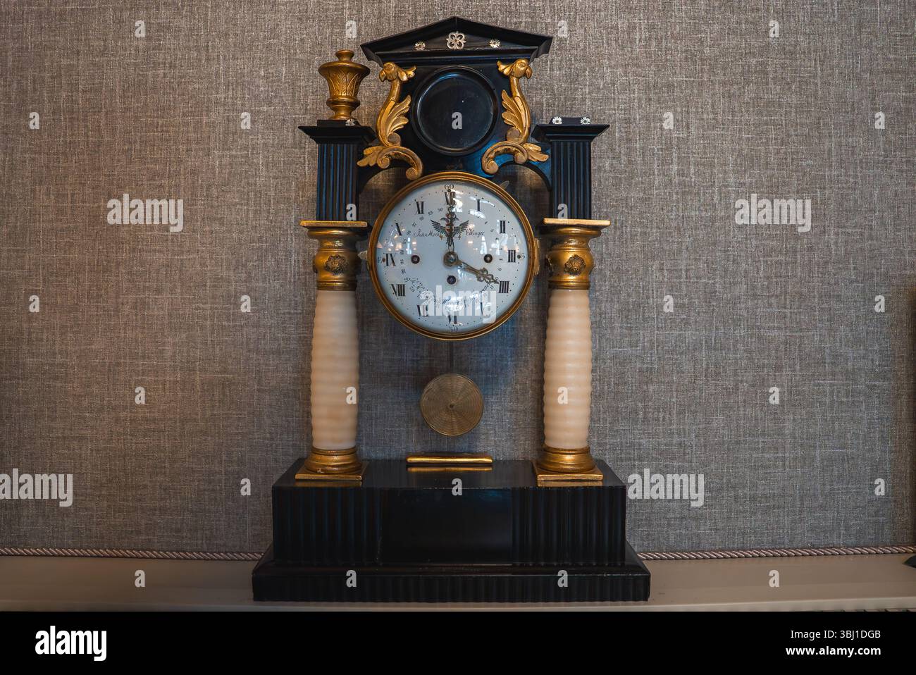 Verzierte antike Uhr mit Schwarz-Gold-Design in luxuriösem Ambiente Stockfoto
