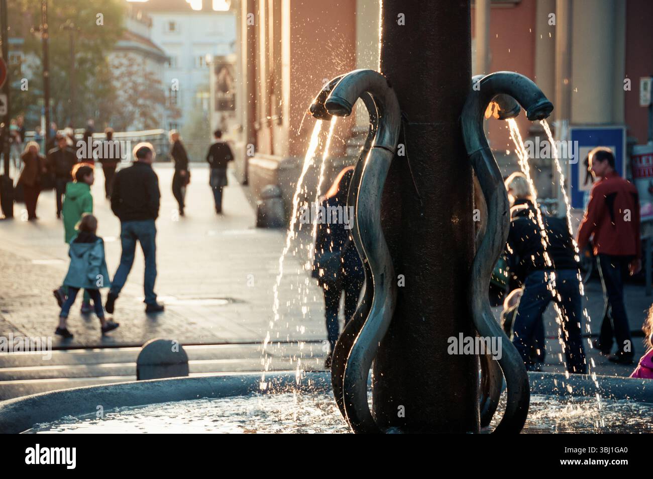 Taubenbrunnen in Graz: Wasser fließt aus vier Schlangenrohren in ein Becken am Schlossbergplatz. Stockfoto