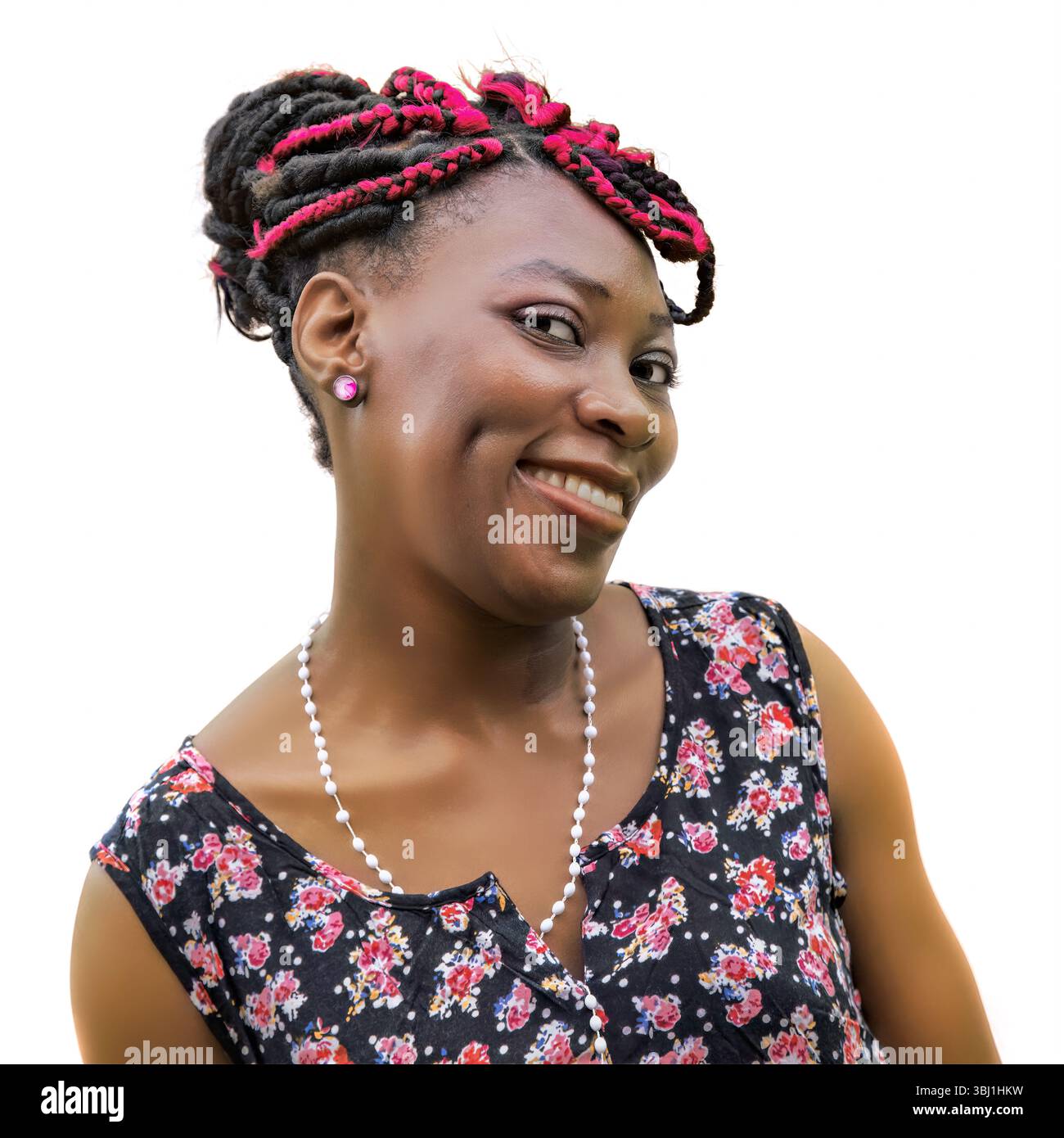 Freche Afrikanerin mit neckendem Ausdruck und schelmischem Lächeln. Verspieltes Porträt mit lustiger Persönlichkeit. Farbenfrohe Kopfbedeckung, Kleid mit Blumenmuster, weiß B Stockfoto