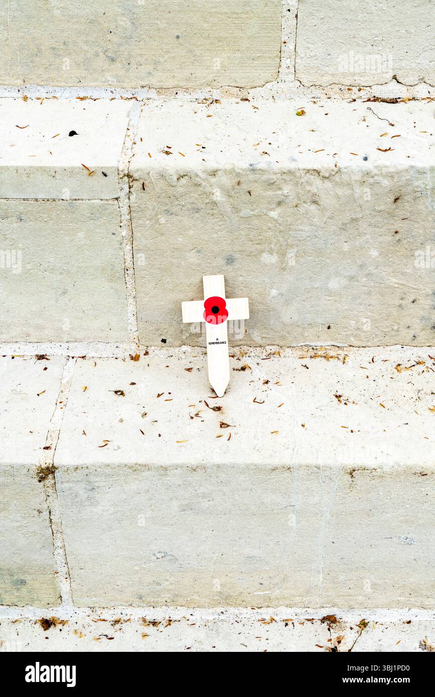 Kleines Erinnerungskreuz und Mohn auf Steinstufen Stockfoto