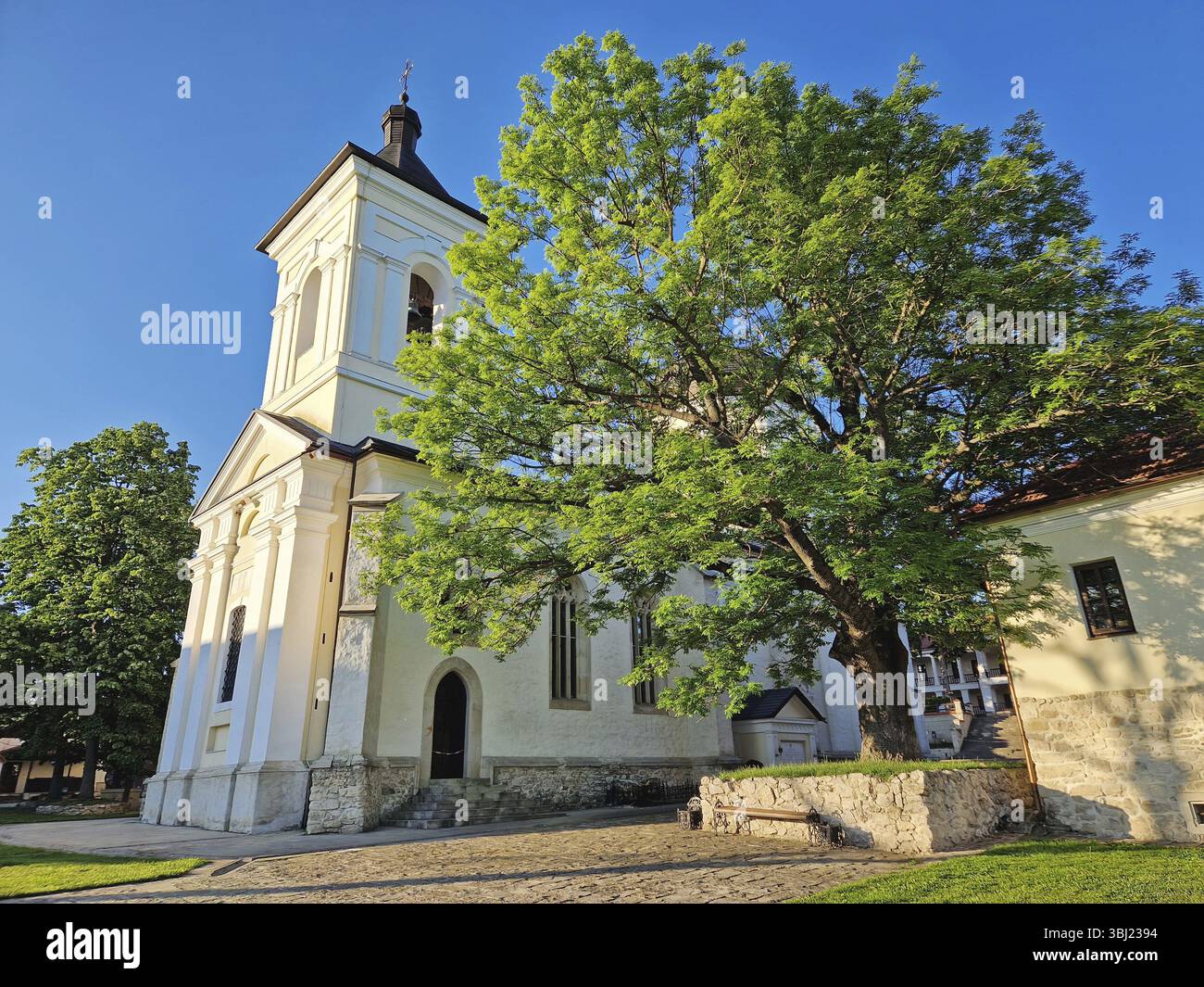 Blick auf den Glockenturm des Klosters Capriana neben einer alten Eiche. Traditionelle christlich-orthodoxe Kirche in der Republik Moldau. Der alte Osten Stockfoto