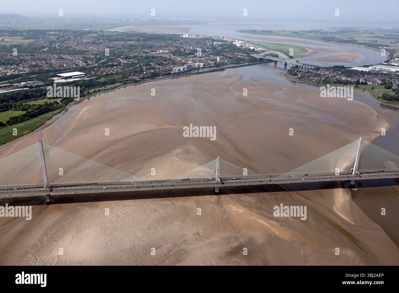 Aus der Vogelperspektive auf die Mersey Gateway Bridge, die die Runcorn Gap mit der Silver Jubilee Bridge in der Ferne flussabwärts des River Mersey überspannt Stockfoto