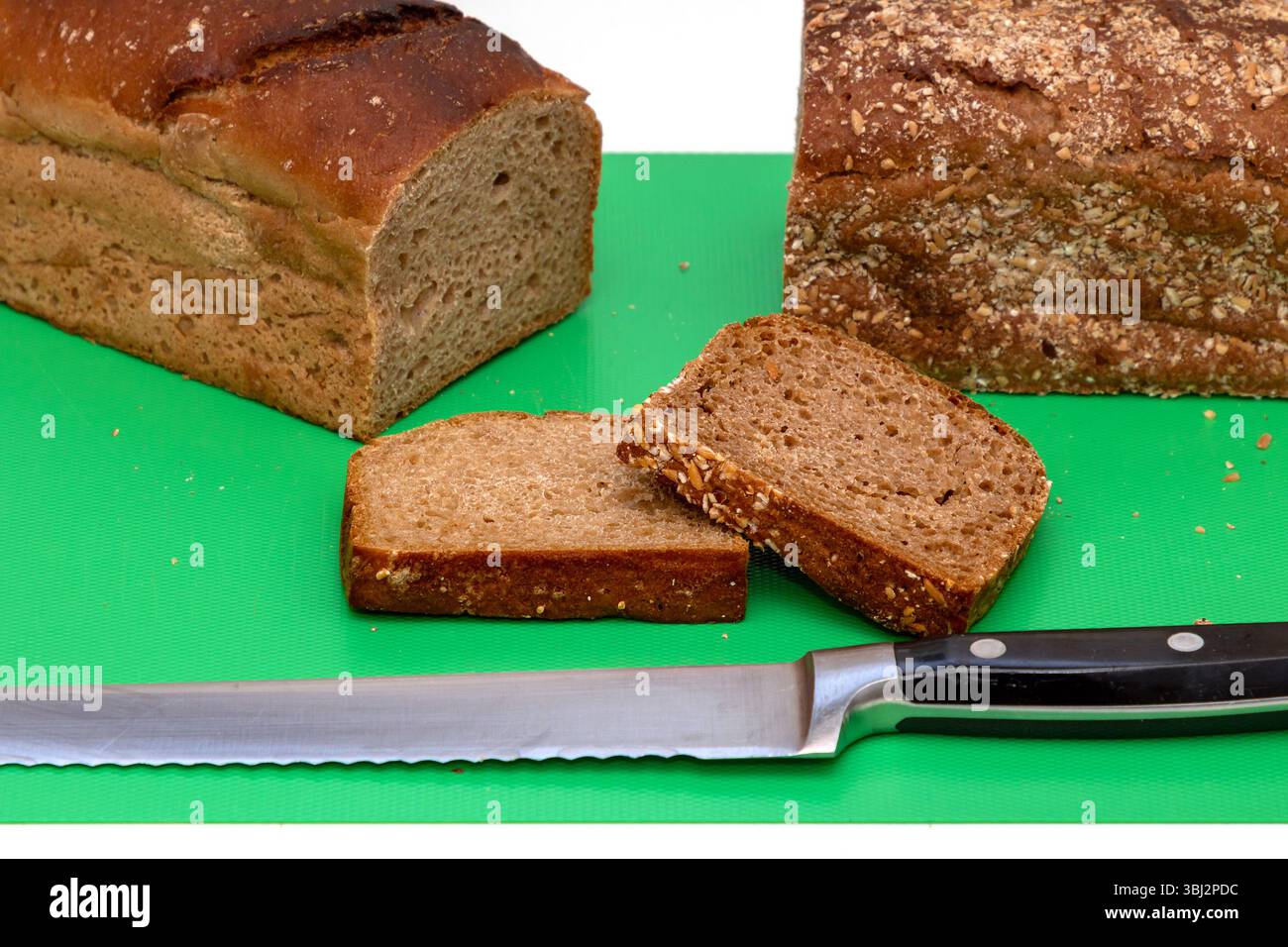 Dunkles gesundes Vollkorn-Roggenbrot, geschnitten mit Messer an Bord Stockfoto