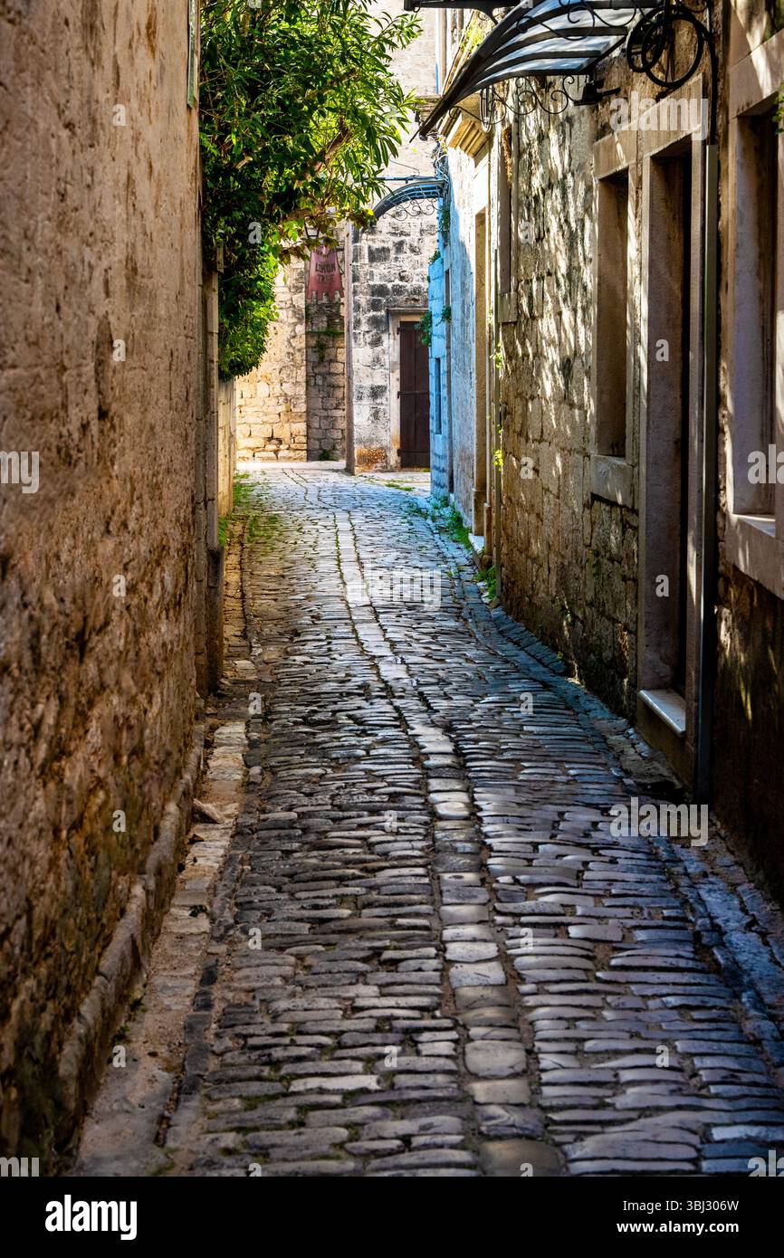 Enge mittelalterliche Kopfsteinpflasterstraße in Trogir, Kroatien. Stockfoto