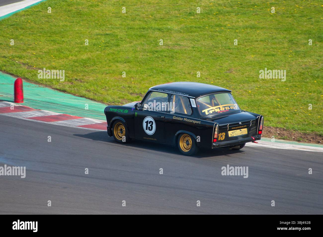 Trabant 601 Rennwagen mit Nummer 13, der an einem Motorsport-Event im Autodrom Most in Tschechien teilnahm. Das alte ostdeutsche Fahrzeug ist fahrend gesehen Stockfoto