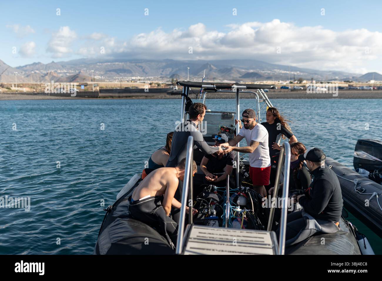 Gruppe von Tauchern, die ihre Tauchausrüstung auf einem Boot vorbereiten, bevor sie in den Ozean tauchen Stockfoto