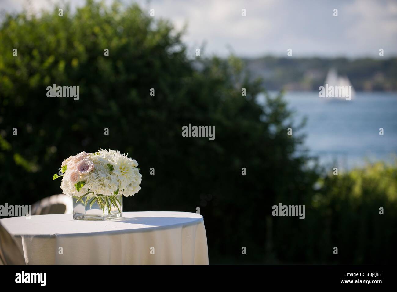 Hochzeitstisch am Meer mit elegantem Blumenaufsatz Stockfoto