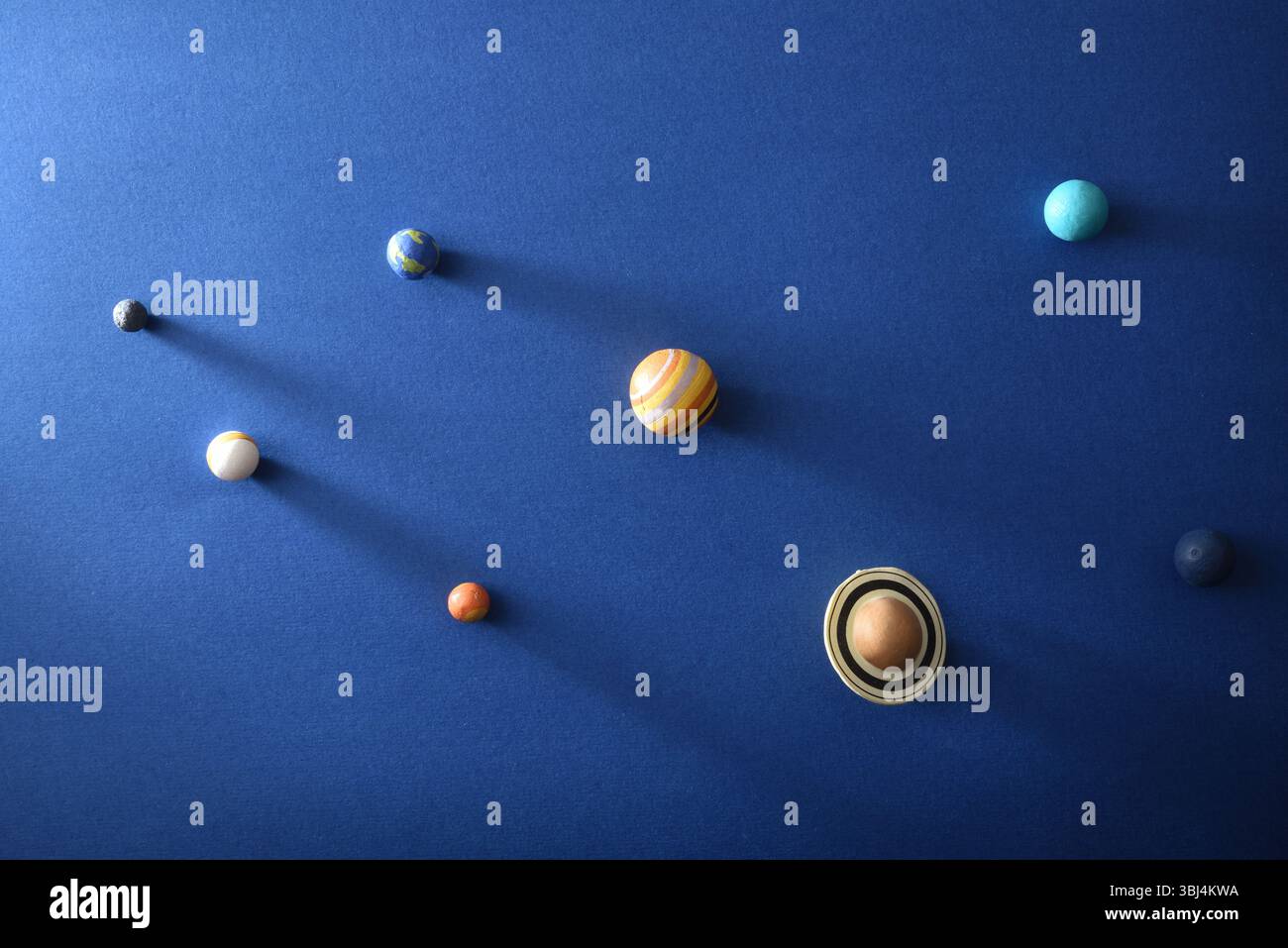 Sonnensystemkonzept mit Planeten auf strukturiertem blauem Karton. Draufsicht. Stockfoto