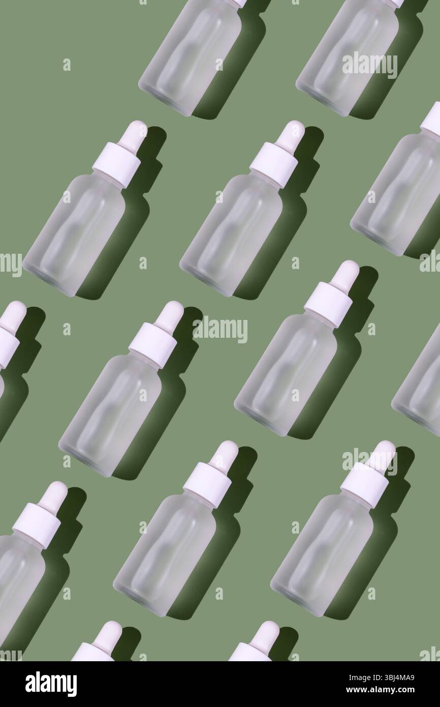 Weiße transparente Kosmetikflasche mit Pipette, grüner Hintergrund Stockfoto