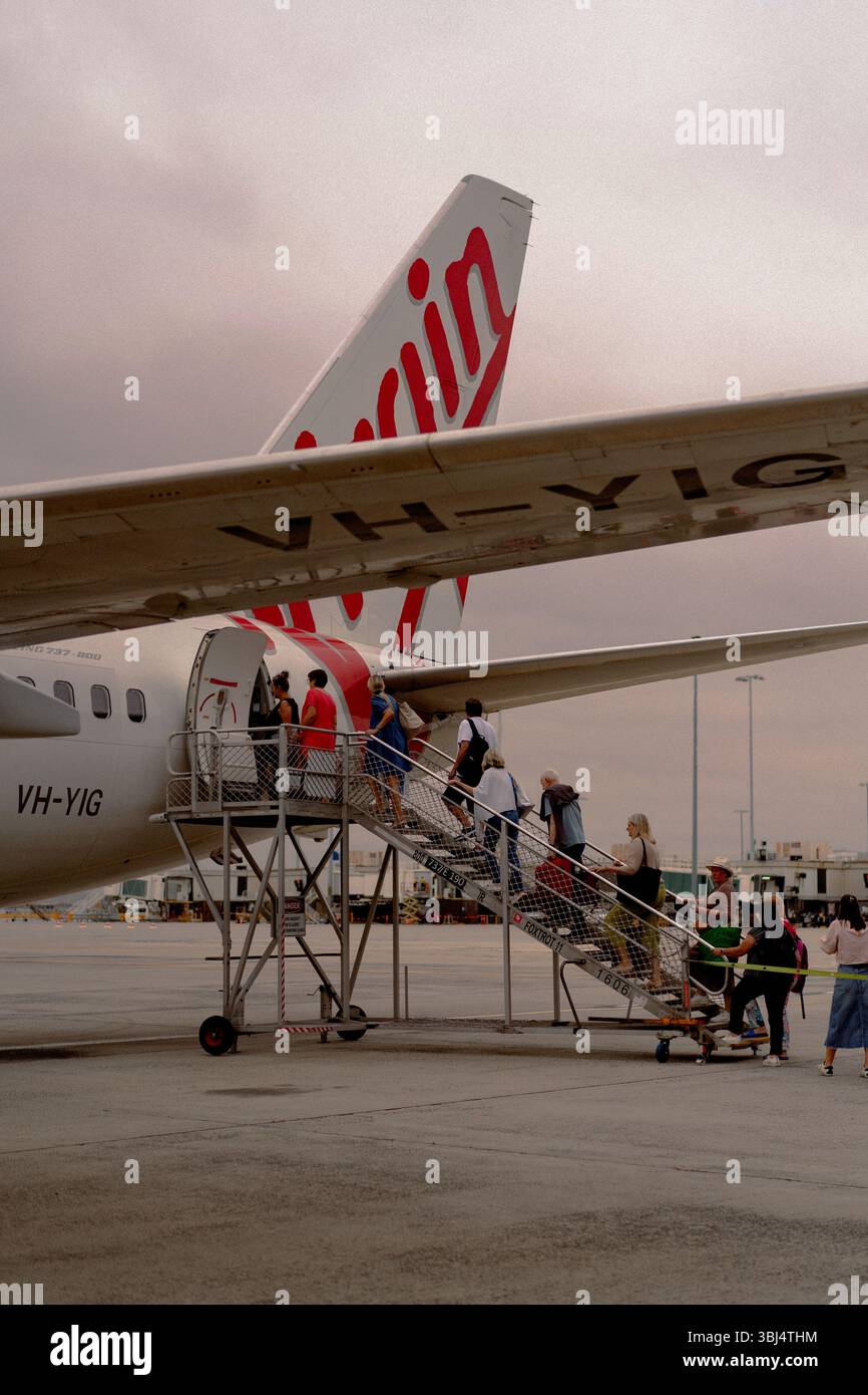 Fluggäste, die Virgin Australia an der Flughafentreppe besteigen Stockfoto