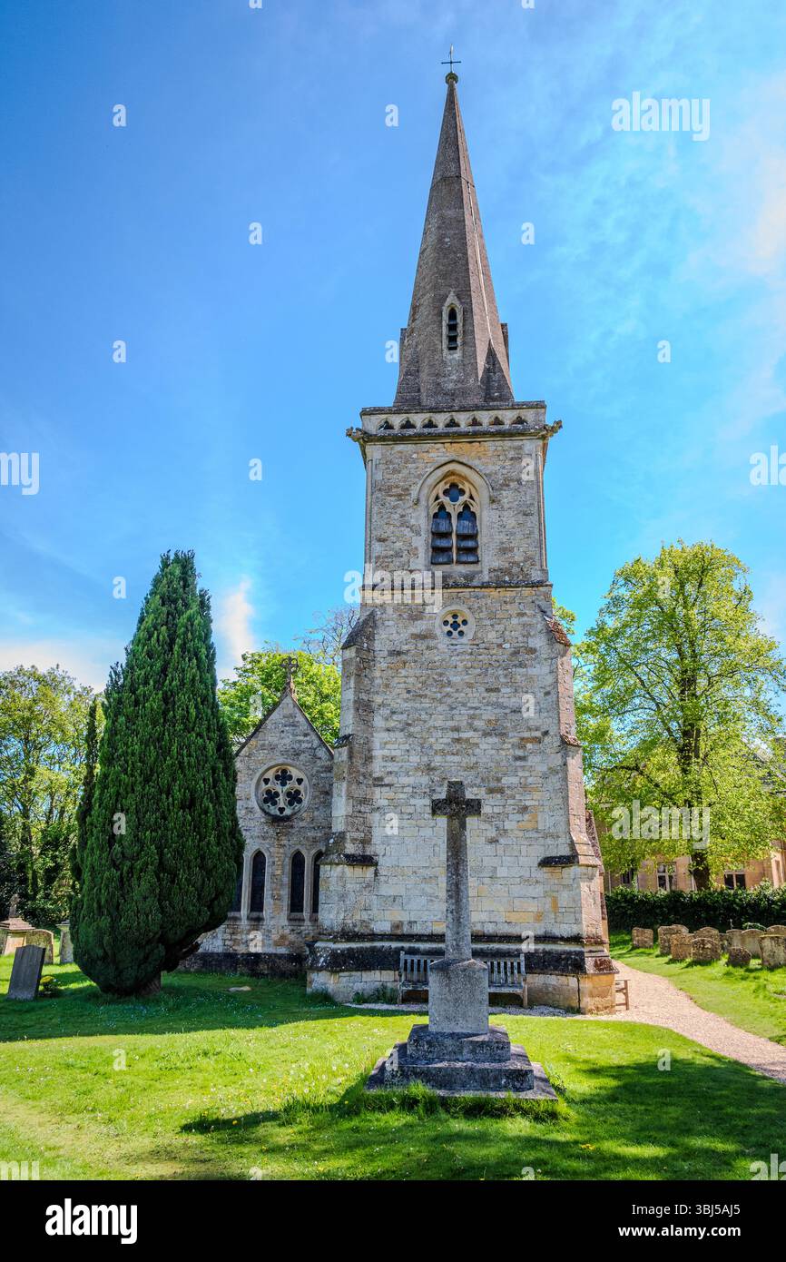 Die Pfarrkirche Saint Mary in Lower Slaughter erhebt sich scharf gegen einen seltenen klaren blauen Himmel, unter der kühnen Frühlingssonne Stockfoto