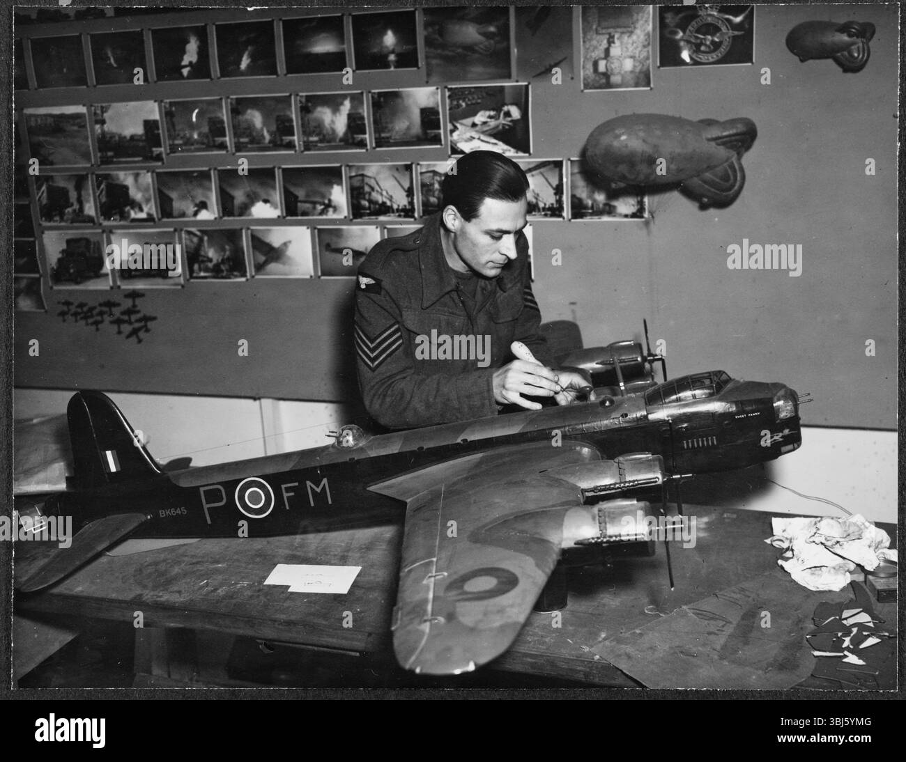 RAF-Pilot Ray Morse arbeitete an einem Modell eines Stirling-Flugzeugs in der Modellwerkstatt der RAF Iver Heath, Pinewood Studios, Buckinghamshire, für den Einsatz in einem Film der RAF Film Production Unit, 1942–43. Ramon „Ray“ Morse wurde 1907 in Mile End geboren, seine Familie emigrierte nach dem Ersten Weltkrieg nach Kanada. Nach seiner Rückkehr nach Großbritannien arbeitete er als Werbekünstler und Maskenbildner in Gainsborough sowie als Tänzer und Sänger im Theater. Er schuf auch Modelle für Scientific Films und GB Instructional. Während des 2. Weltkriegs diente er in der RAF Film Production Unit in den Pinewood Studios, wo h Stockfoto