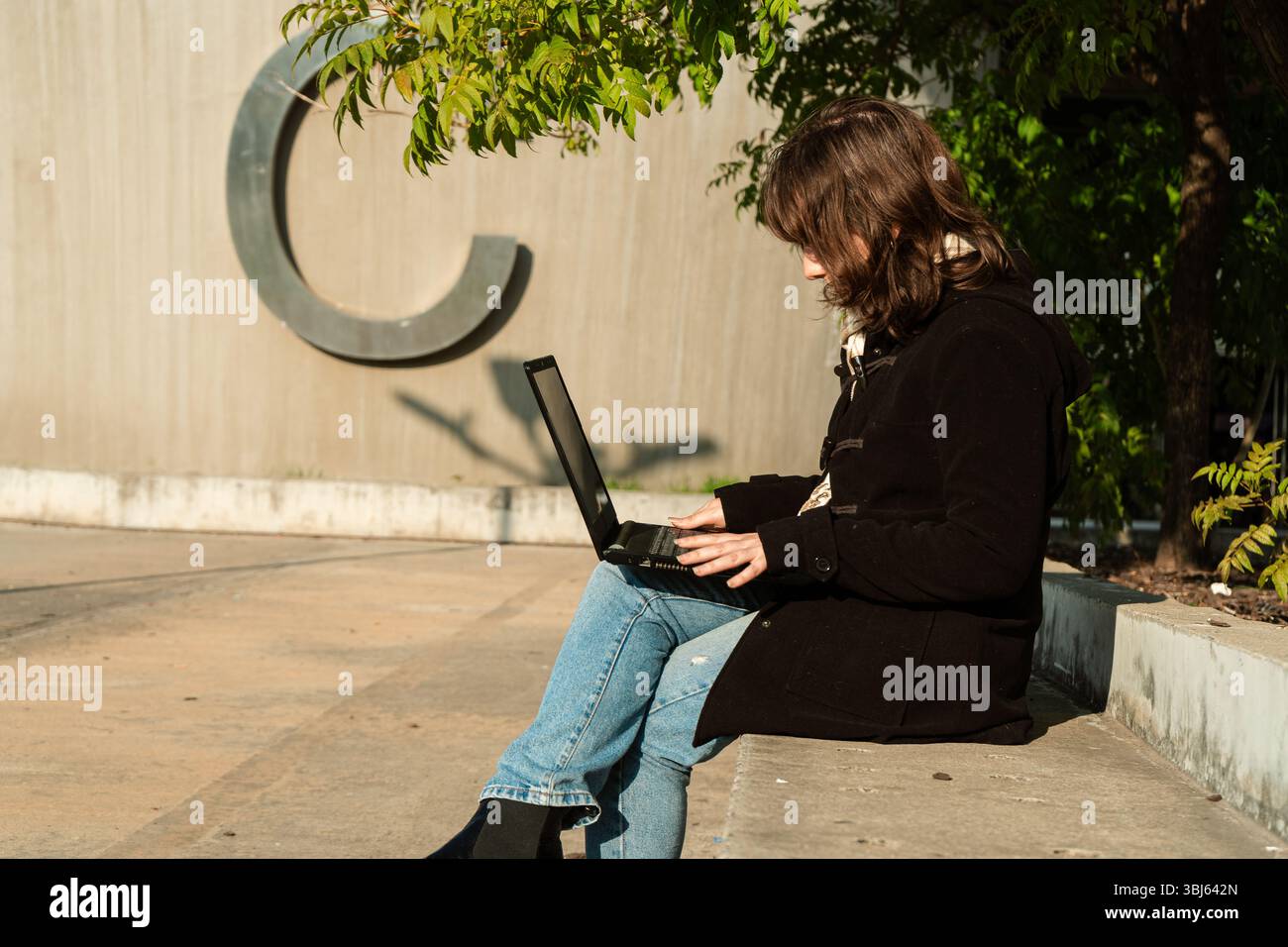 Tight Shot mit Gesichtsausdruck und Handgriffen auf dem Laptop, die Konzentration und Fernarbeit vermitteln. Stockfoto