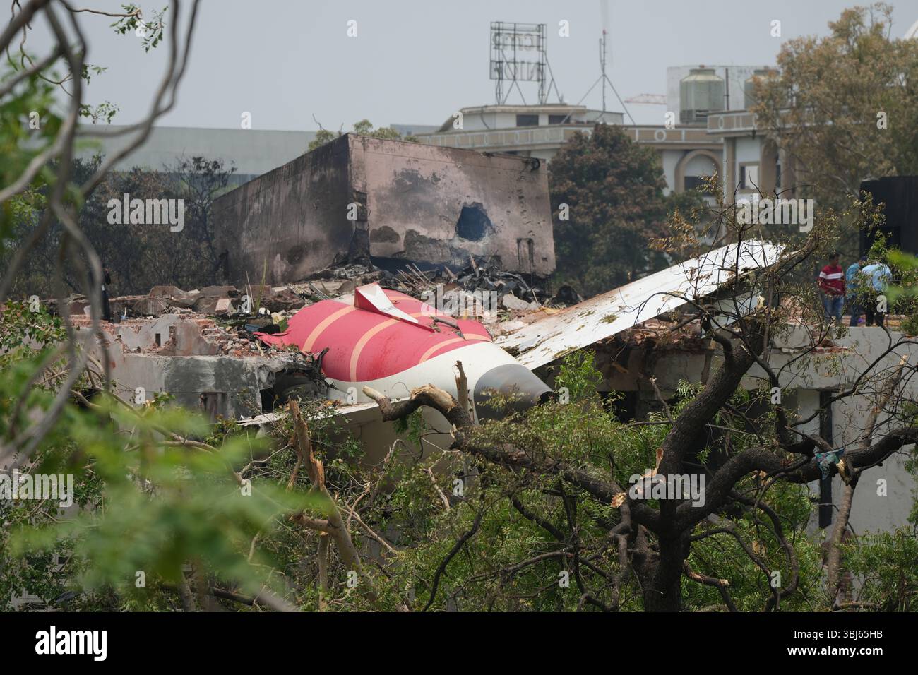 (250613) -- AHMEDABAD, 13. Juni 2025 (Xinhua) -- Menschen stehen neben den Trümmern eines Flugzeugs der Air India, das am 13. Juni 2025 in Ahmedabad im indischen Bundesstaat Gujarat abgestürzt ist. Die indische Regierung hat eine förmliche Untersuchung des tragischen Flugzeugabsturzes von Air India am Donnerstag eingeleitet, bestätigte der Zivilluftfahrtminister RAM Mohan Naidu in einem Social-Media-Beitrag. Laut neuesten Medienberichten waren bereits 265 Leichen in ein Krankenhaus der örtlichen Regierung in Ahmedabad gebracht worden, wo der Flugzeugabsturz stattgefunden hatte. (Xinhua) Stockfoto