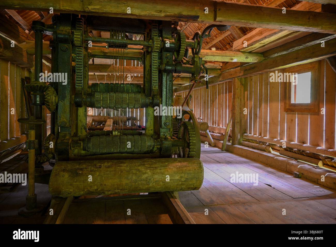 Antike Sägewerke stehen in einem rustikalen Holzgebäude und zeigen die historische Bedeutung industrieller Prozesse. Stockfoto