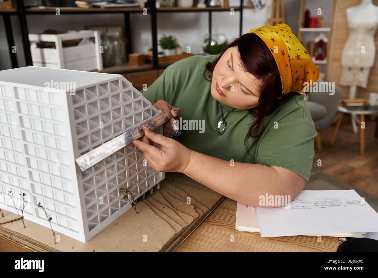 Eine Frau bastelt geschickt ein Architekturmodell in ihrem Atelier und zeigt ihre Kreativität. Stockfoto