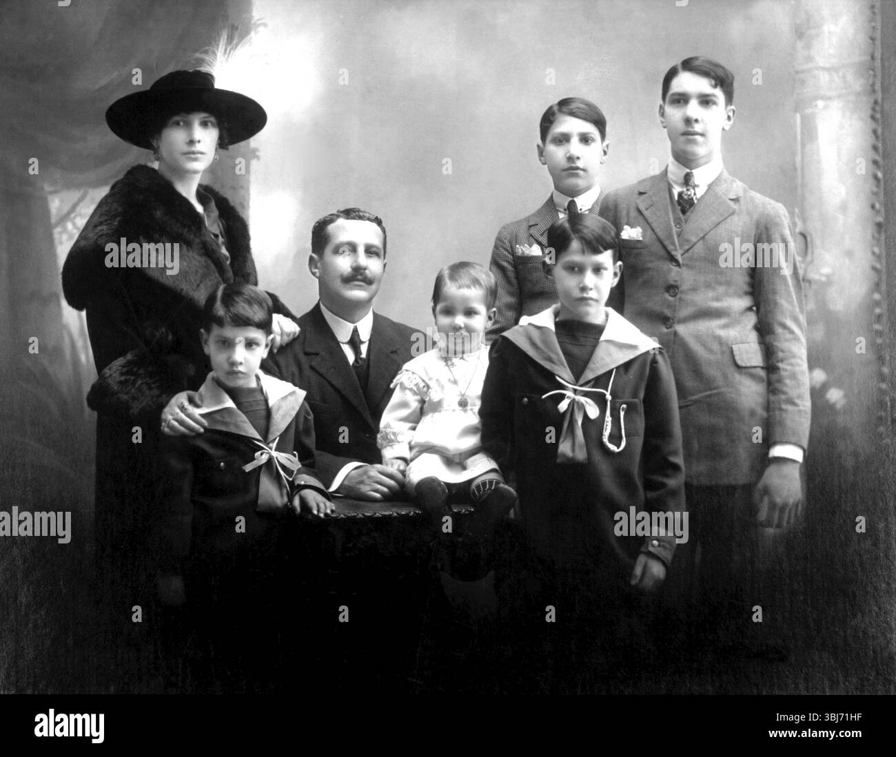 Familie mit 5 Kindern, Porträt einer Familie in traditioneller Kleidung, formelles Gruppenfoto, historisches Foto Stockfoto