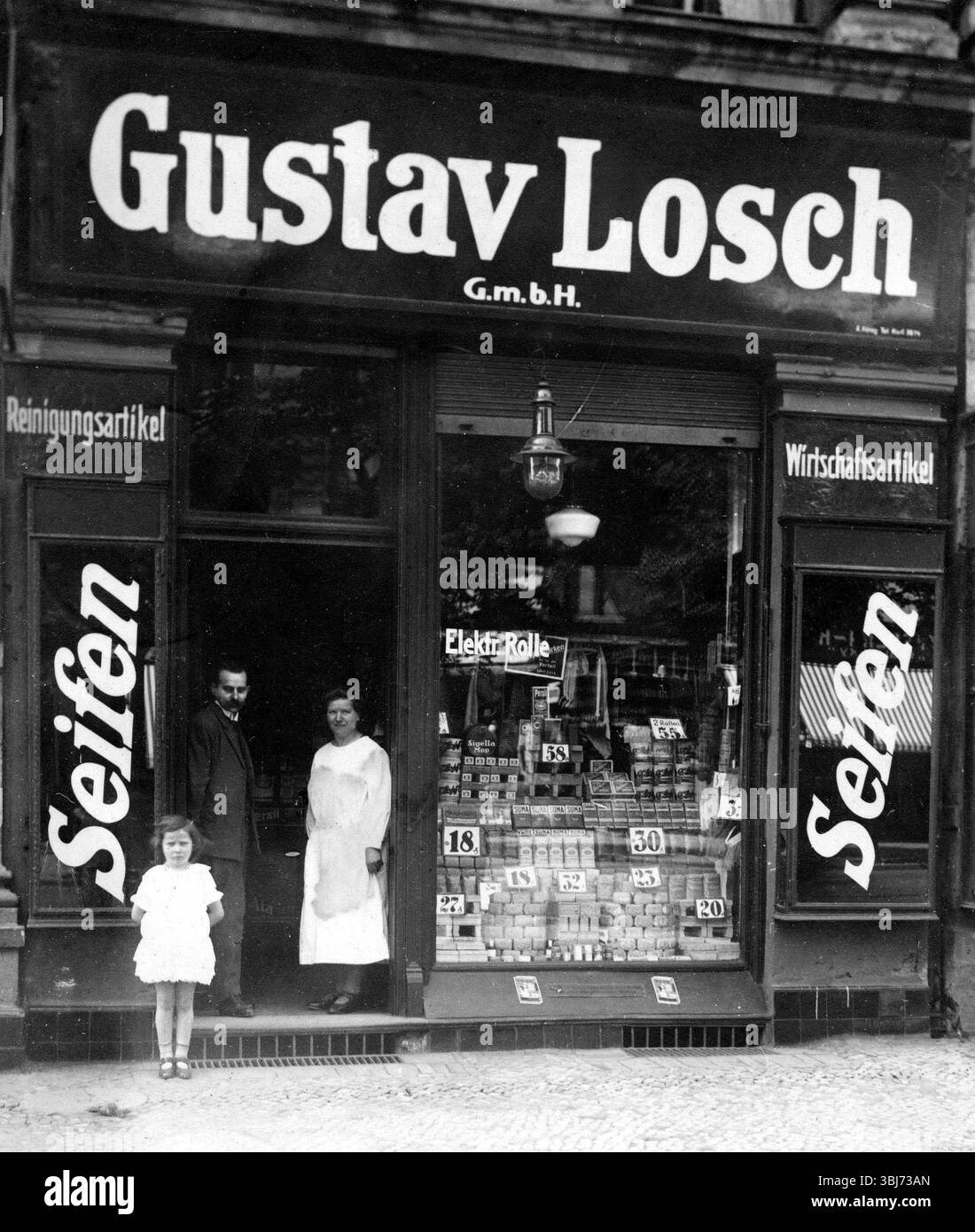 Seifenladen, 1910, Ein Mann, eine Frau und ein Kind stehen vor einem alten Seifenladen mit einem großen Schild draußen, historisches Foto Stockfoto