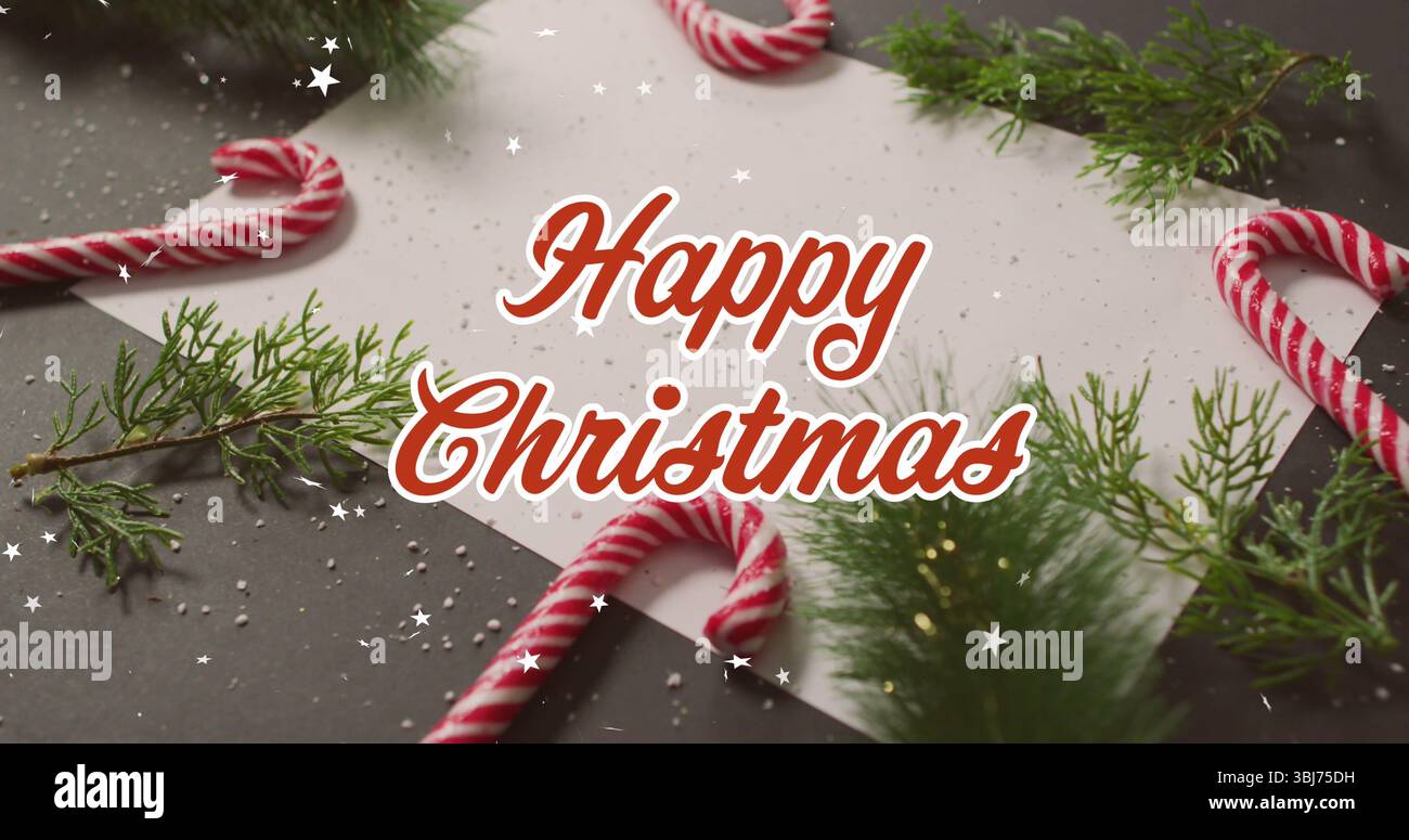 Mit festlicher Tischplatte auf dunklem Tisch, mit Zuckerstangen, immergrünen Zweigen und weißem Blatt Stockfoto