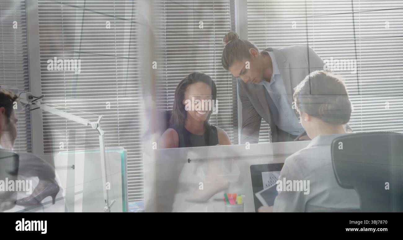 Mitarbeiter in schwarzem Kleid, der den Monitor mit einem Kollegen im Büro überprüft, mit Stifthalter Stockfoto