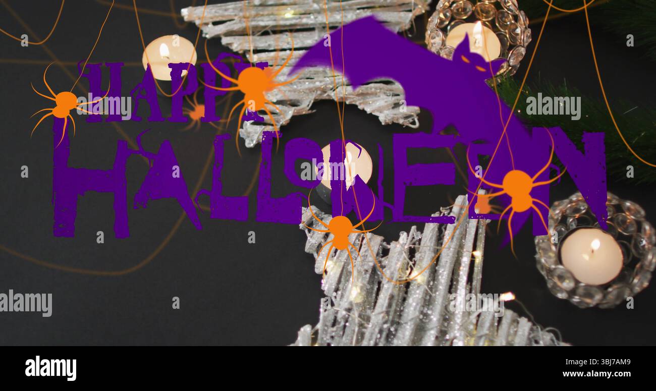 Halloween-Text mit Fledermaus-Silhouette über der Tischplatte, mit beleuchteten Kerzen und orangefarbenen Spinnen Stockfoto