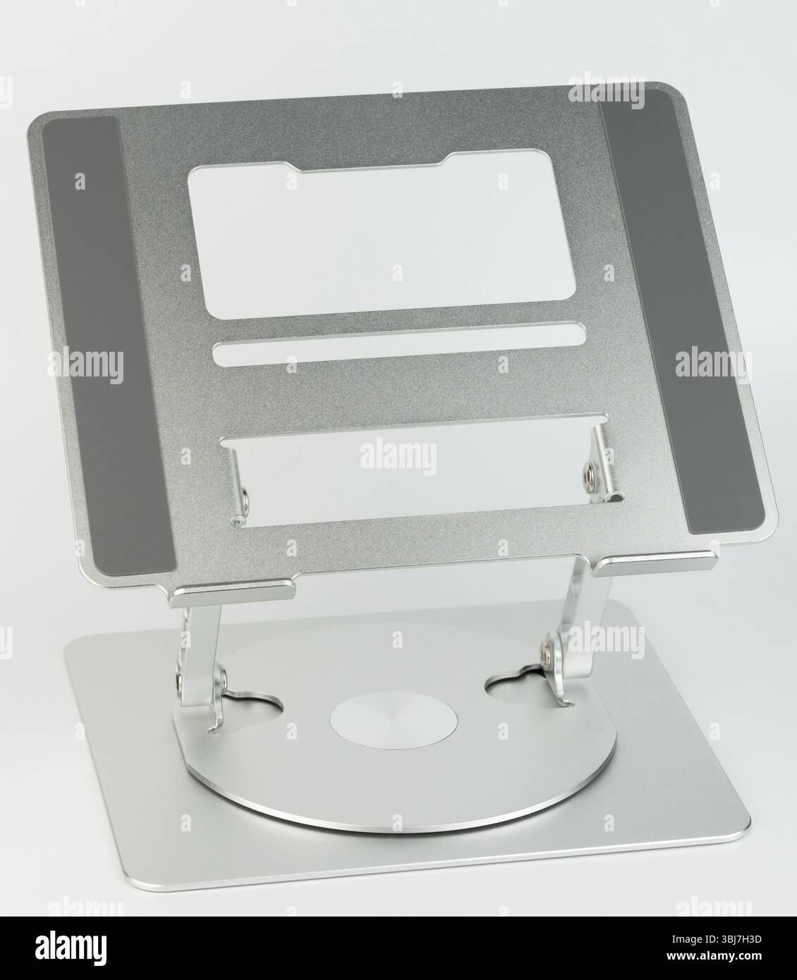 Der schlanke Laptop-Ständer aus Metall ist in Höhe und Winkel verstellbar und sorgt so für eine gute Körperhaltung beim Arbeiten am Schreibtisch. Stockfoto