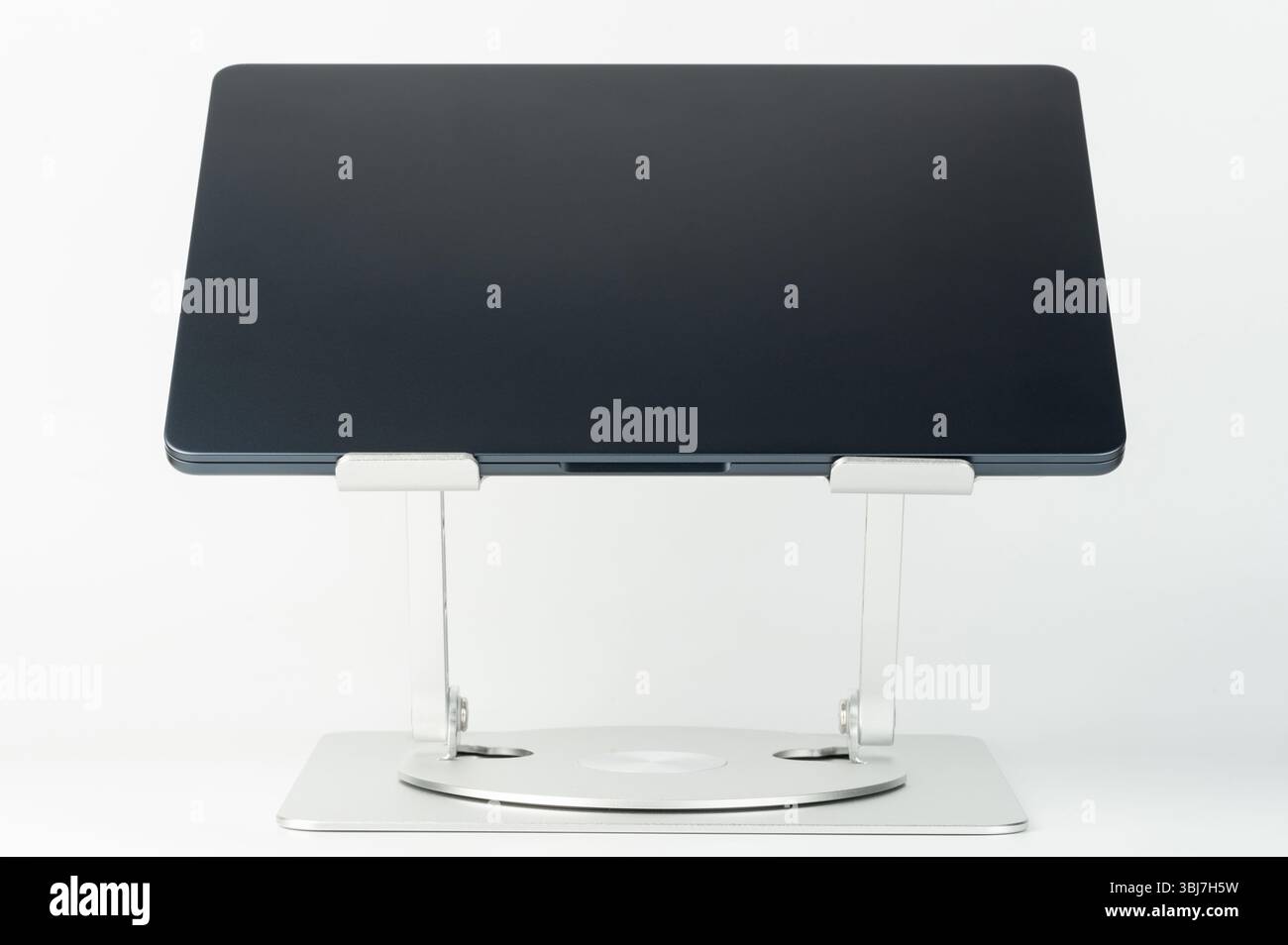 Der schlanke Laptop-Standfuß erhöht durch die verstellbare Höhe und den verstellbaren Winkel den Komfort und die Produktivität beim Arbeiten oder Studieren zu Hause. Stockfoto