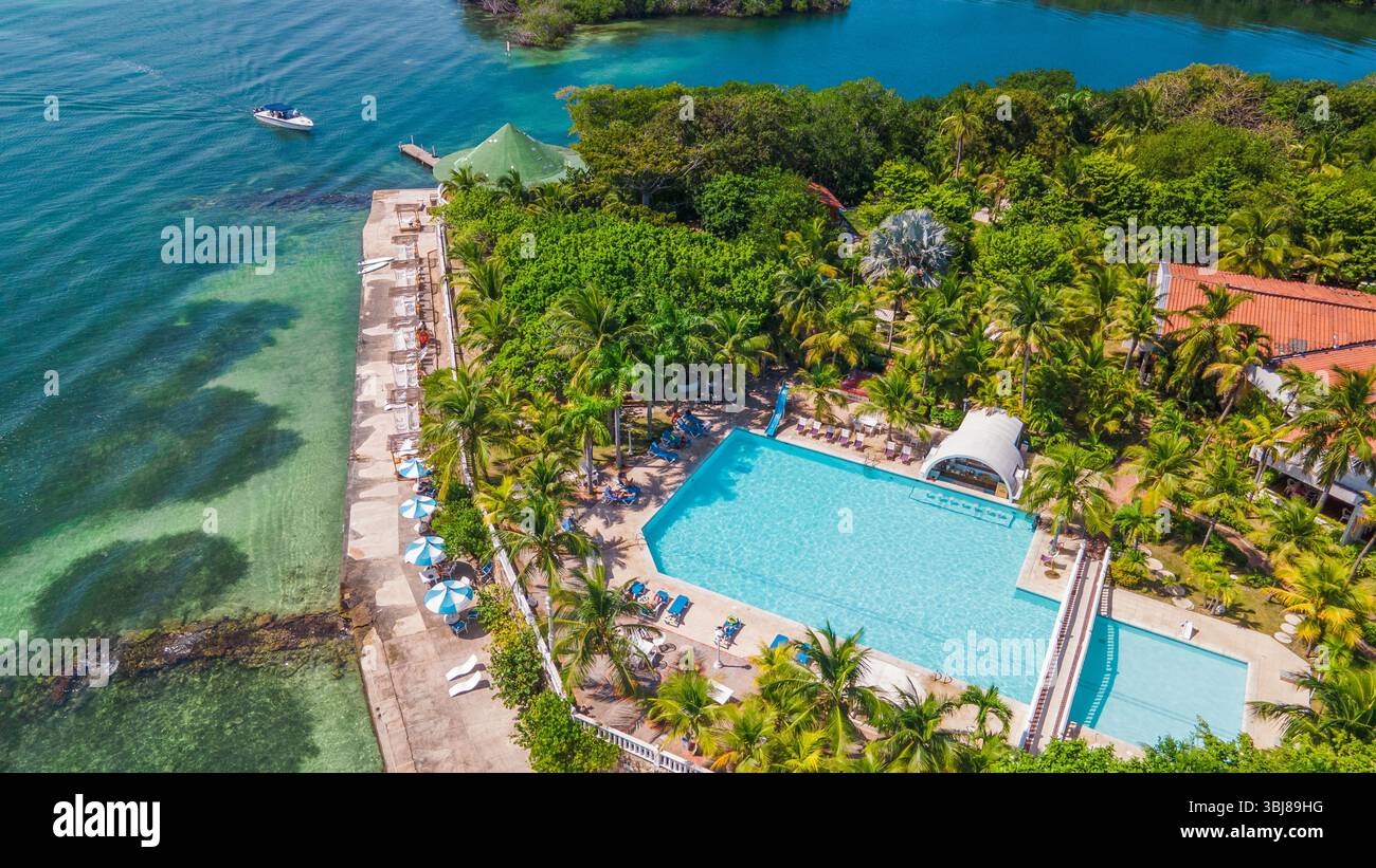 Atemberaubender Blick aus der Vogelperspektive auf einen Resort-Pool, umgeben von üppigem Grün und malerischem Wasser auf den Rosario-Inseln in der Nähe von Cartagena, Kolumbien. Stockfoto