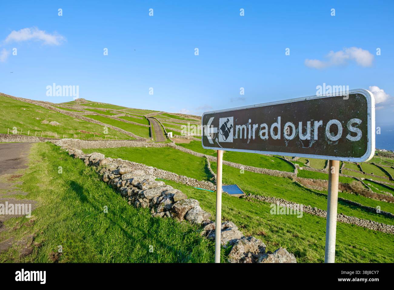 Ländliche Landschaft der Azoren mit Miradouros-Schild und Steinmauern in Serra do Cume, Terceira, Azoren. Grüne, sanfte Hügel, malerische Aussichtspunkte, trad Stockfoto