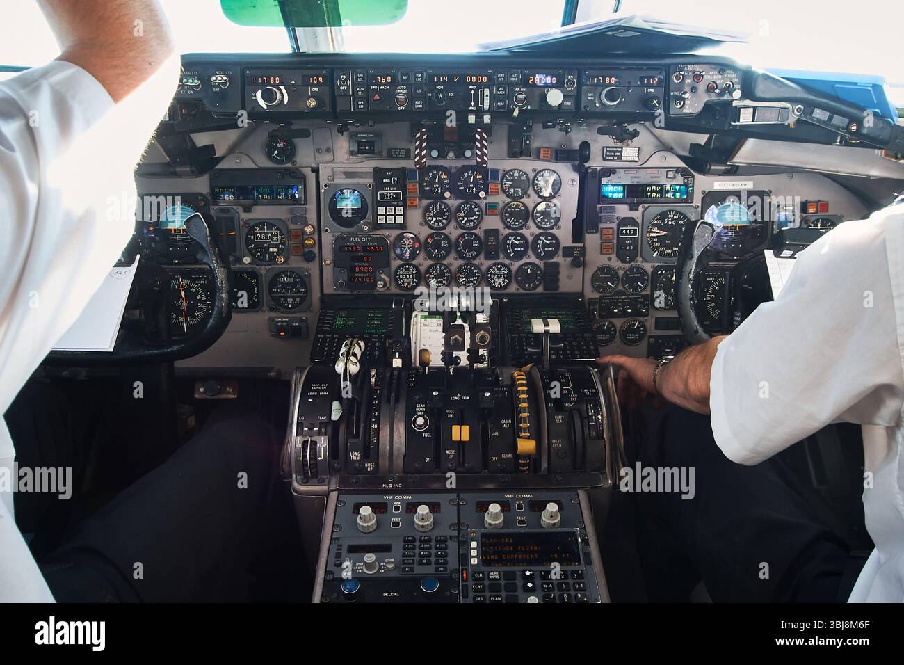 Flugzeugcockpit mit Piloten, die während eines Fluges die Steuerung steuern, mit komplexen Instrumenten und Technologien Stockfoto