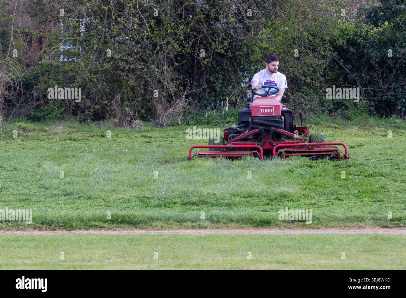 In Vorbereitung auf die Saison 2017 bereitet sich der Stradbroke Village Cricket Club in Suffolk auf einen Toro Gang Rasenmäher vor, um das Außenfeld zu schneiden. Stockfoto