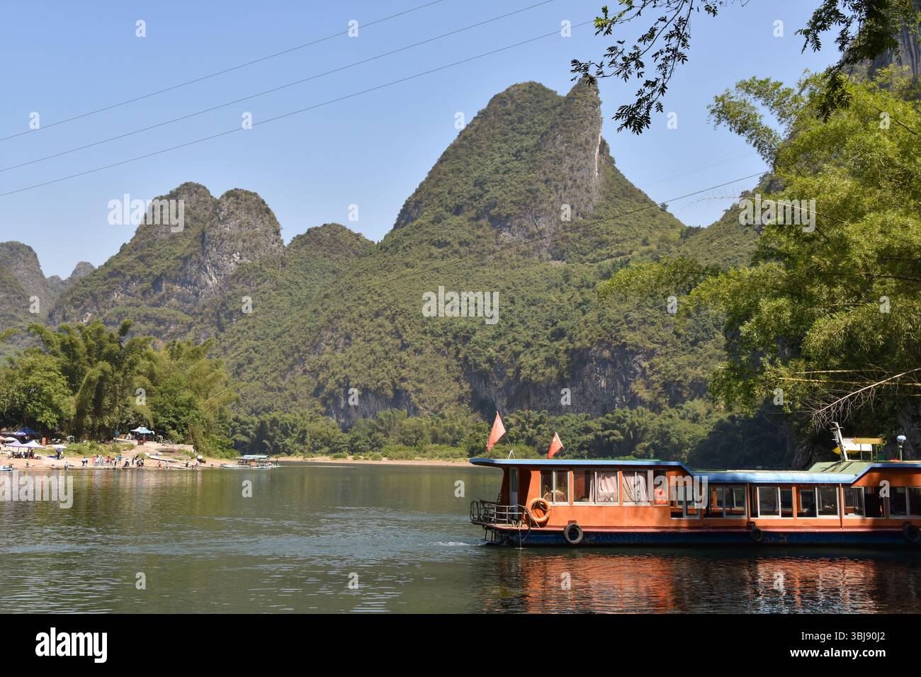 Eine ruhige Szene mit Booten auf dem Li-Fluss unter den Karstbergen in Xingping, Yangshuo Stockfoto