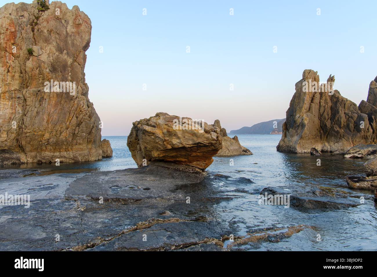 Alte Felsformationen an der Küste, die Eine ruhige Meereslandschaft umrahmen Stockfoto