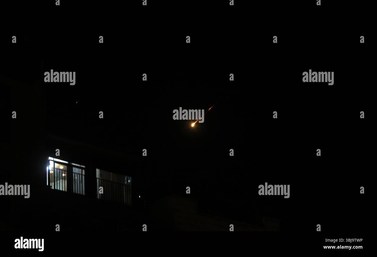 Hebron. Juni 2025. Raketenspuren sind über der Stadt Hebron im südlichen Westjordanland während der Raketenangriffe des Iran auf Israel am 13. Juni 2025 zu sehen. Israel startete am frühen Freitag Luftangriffe auf die iranische Hauptstadt Teheran und andere Städte im ganzen Land mit dem Ziel, die nukleare Infrastruktur des Iran, die Produktion ballistischer Raketen und die militärischen Fähigkeiten zu zerstören. Der Iran reagierte am Freitagabend auf die Angriffe, indem er eine Salve ballistischer Raketen gegen militärische Ziele in Israel abfeuerte. Quelle: Mamoun Wazwaz/Xinhua/Alamy Live News Stockfoto