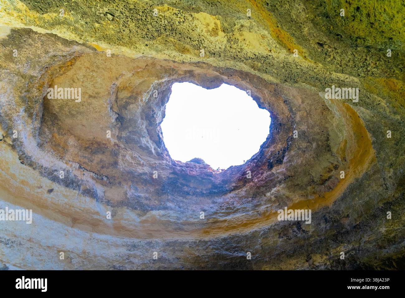 Natürliche Öffnung in einer Benagil-Höhle entlang der Algarve-Küste in Portugal. Der Himmel vom Inneren der Höhle auf dem Höhlentourenboot aus gesehen. Stockfoto