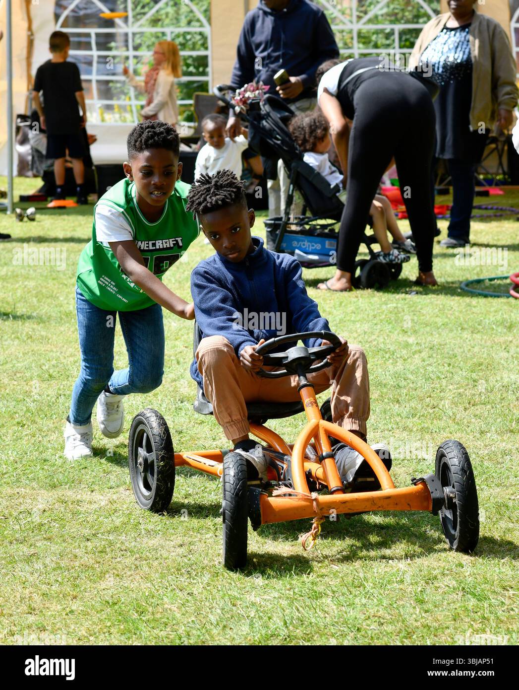 Jungs, die mit Spielzeug spielen, gehen auf den Wagen in Großbritannien. Stockfoto