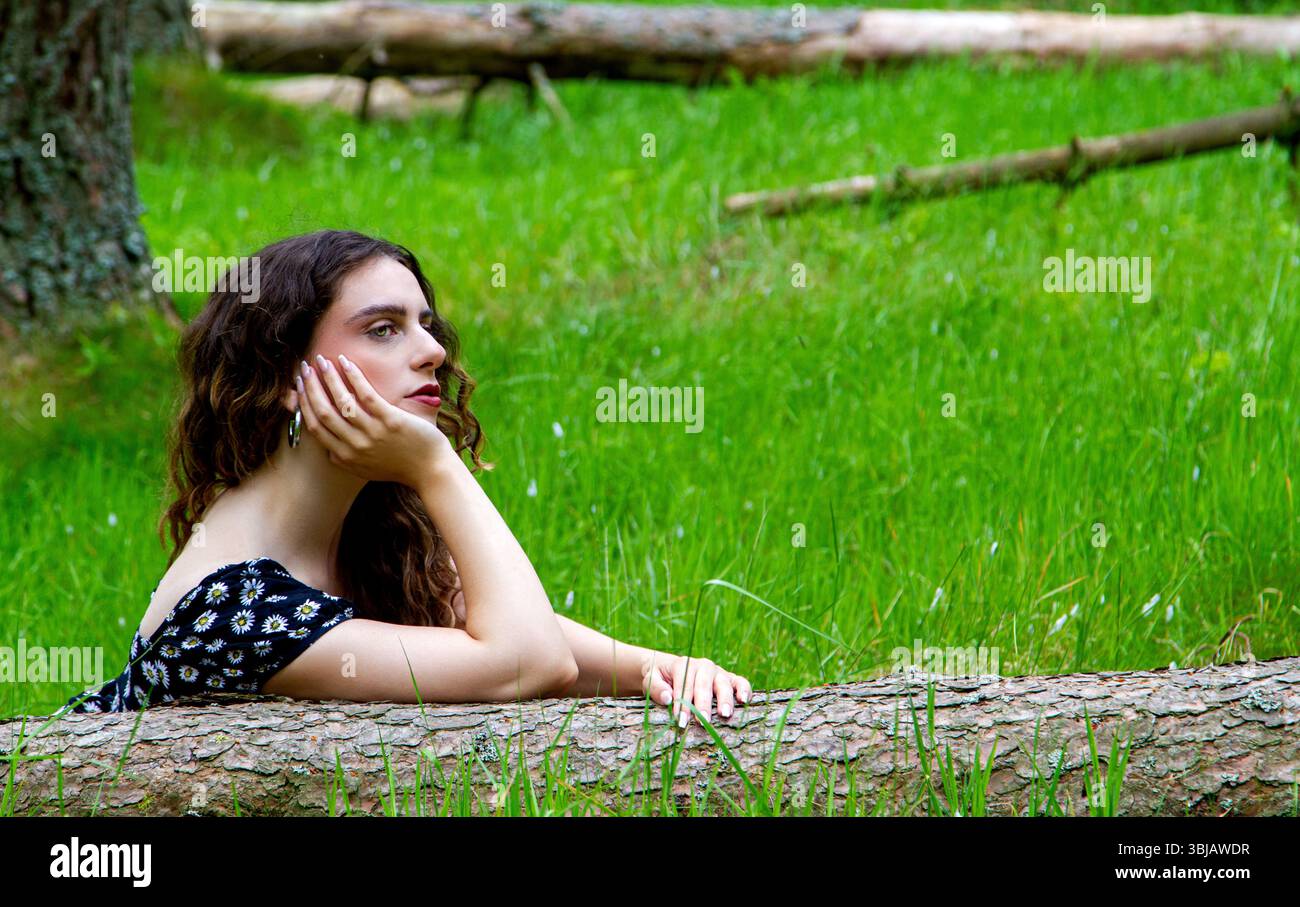 In den Angus Glens in der Nähe von Kirriemuir posiert eine attraktive Frau in der luftigen Frühlingssonne in den Wäldern von Glen Clova in Schottland, Großbritannien Stockfoto