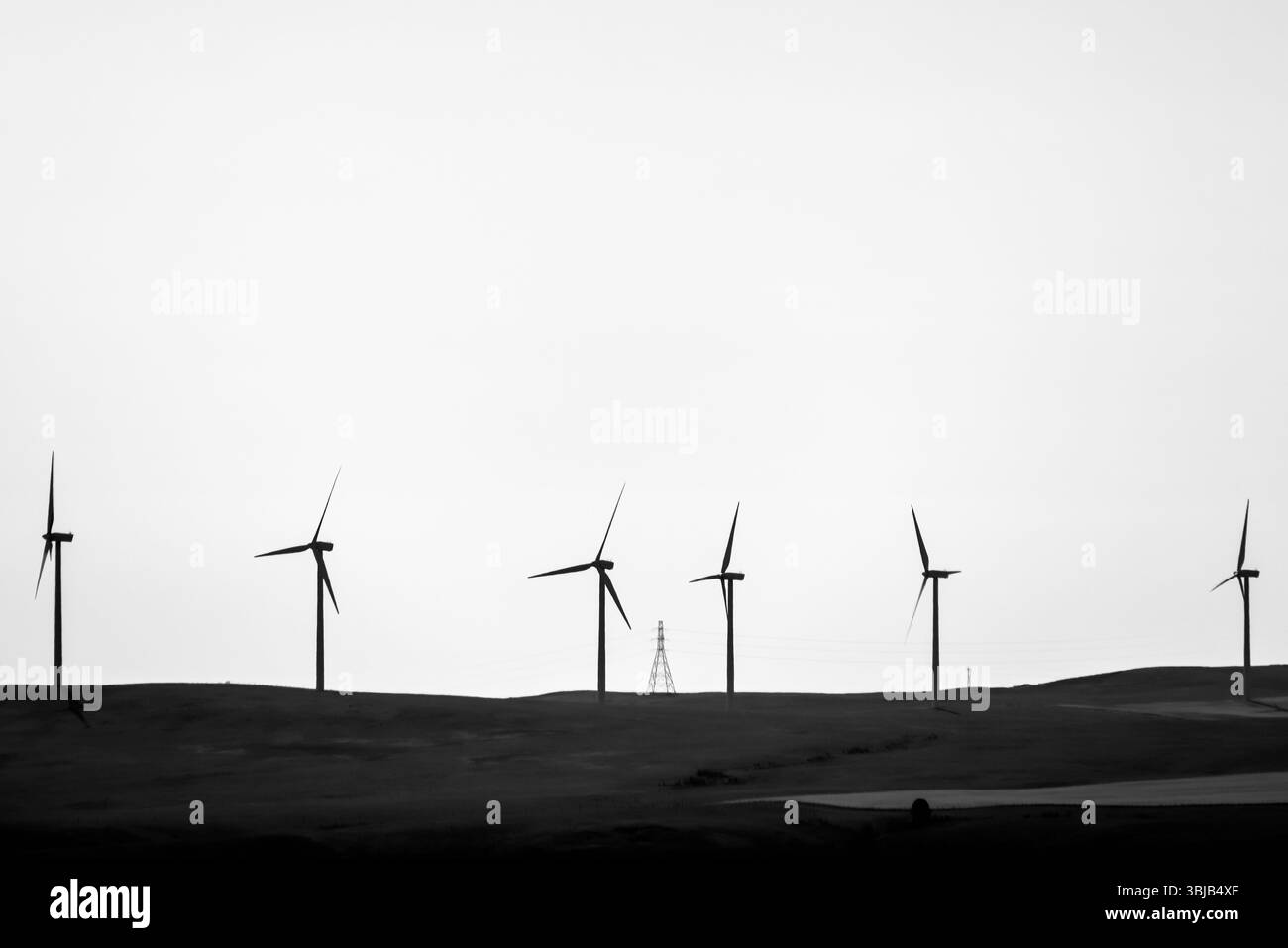 Claresholm, Alberta - 11. Juli 2021: Stromleitungen und Windräder entlang der Autobahnen im Osten Albertas Stockfoto