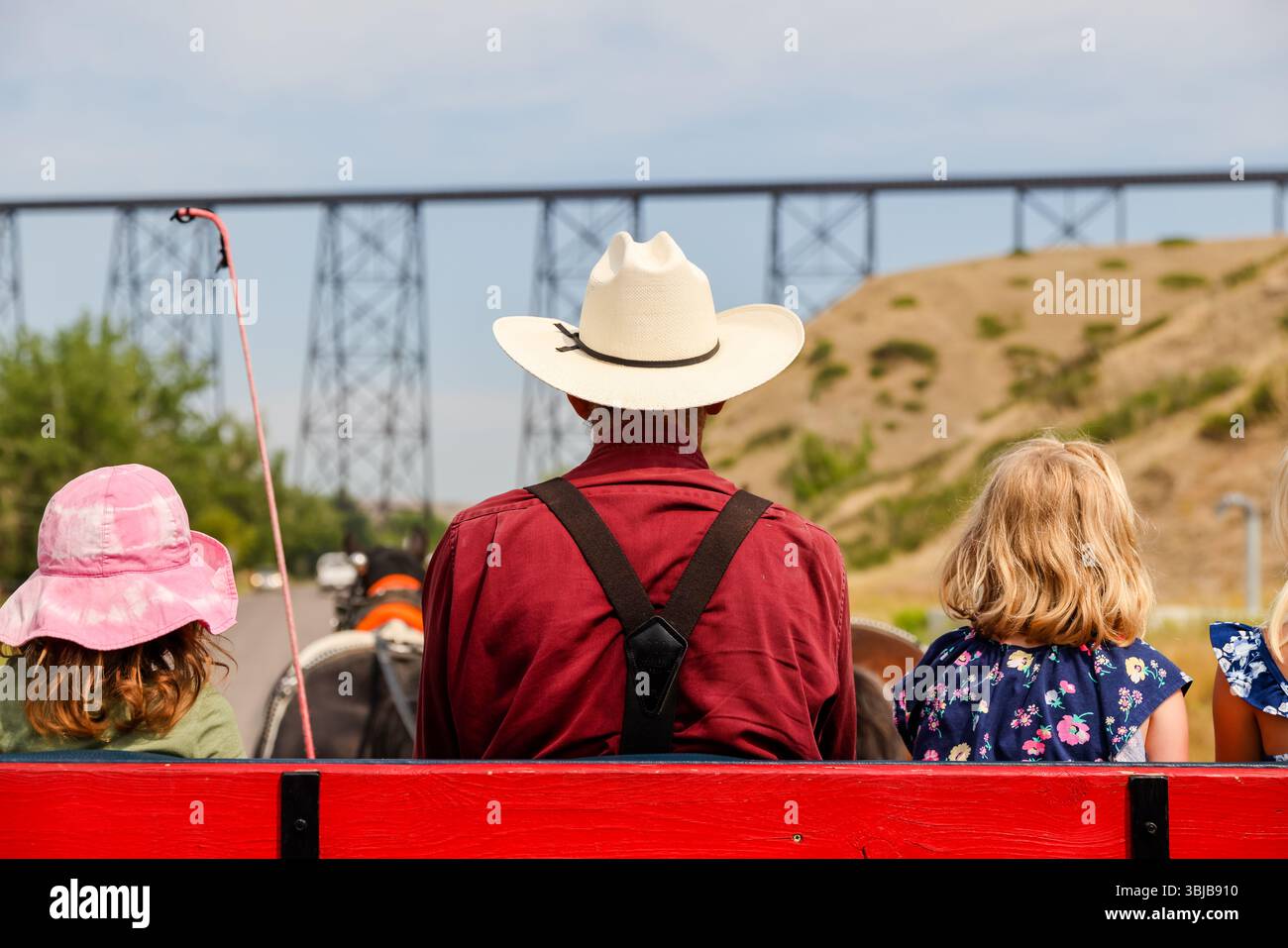 Lethbridge, Alberta - 7. Juli - 2021: Rückansicht von Menschen, die mit einer Pferdekutsche im Old man River Valley in Lethbridge Alberta fahren Stockfoto