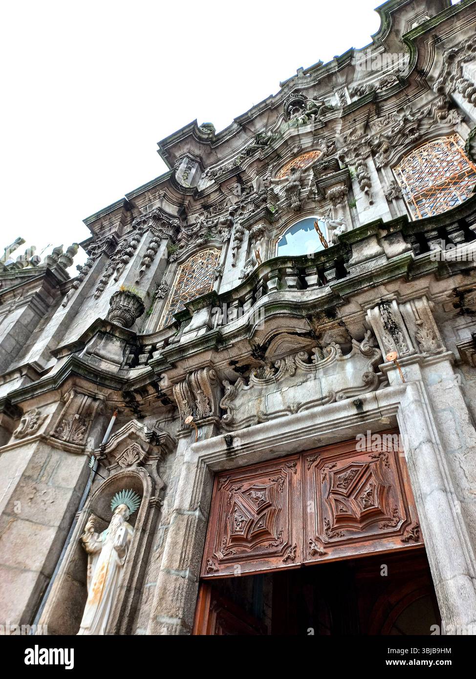 Porto, Portugal. März 30 2024 Detailansicht der reich verzierten Barockfassade von Igreja dos Clérigos mit verzierten Mauerwerken, Holztüren und Stockfoto