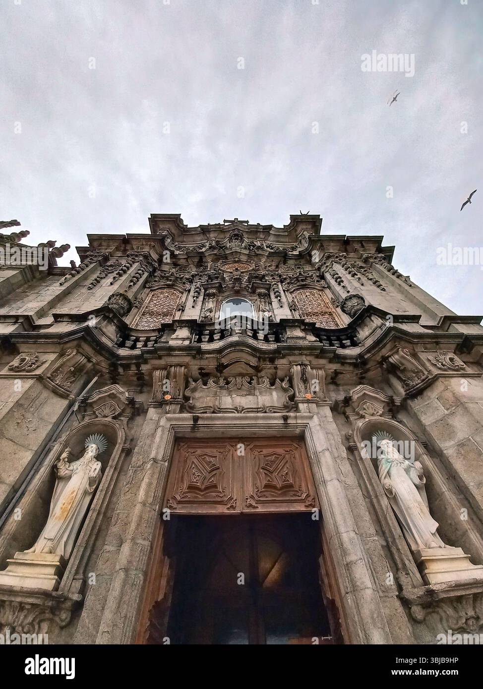 Porto, Portugal. März 30 2024 Detailansicht der reich verzierten Barockfassade von Igreja dos Clérigos mit verzierten Mauerwerken, Holztüren und Stockfoto