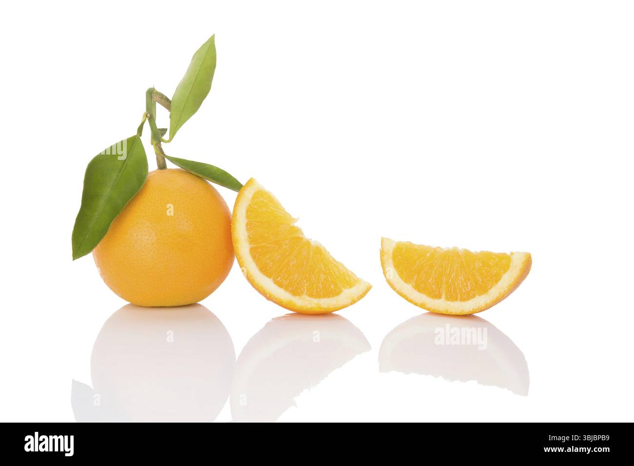 Köstliche ganze Orangen mit Blättern und Scheiben isoliert auf weißem Hintergrund. Gesunde Fruchternährung Stockfoto