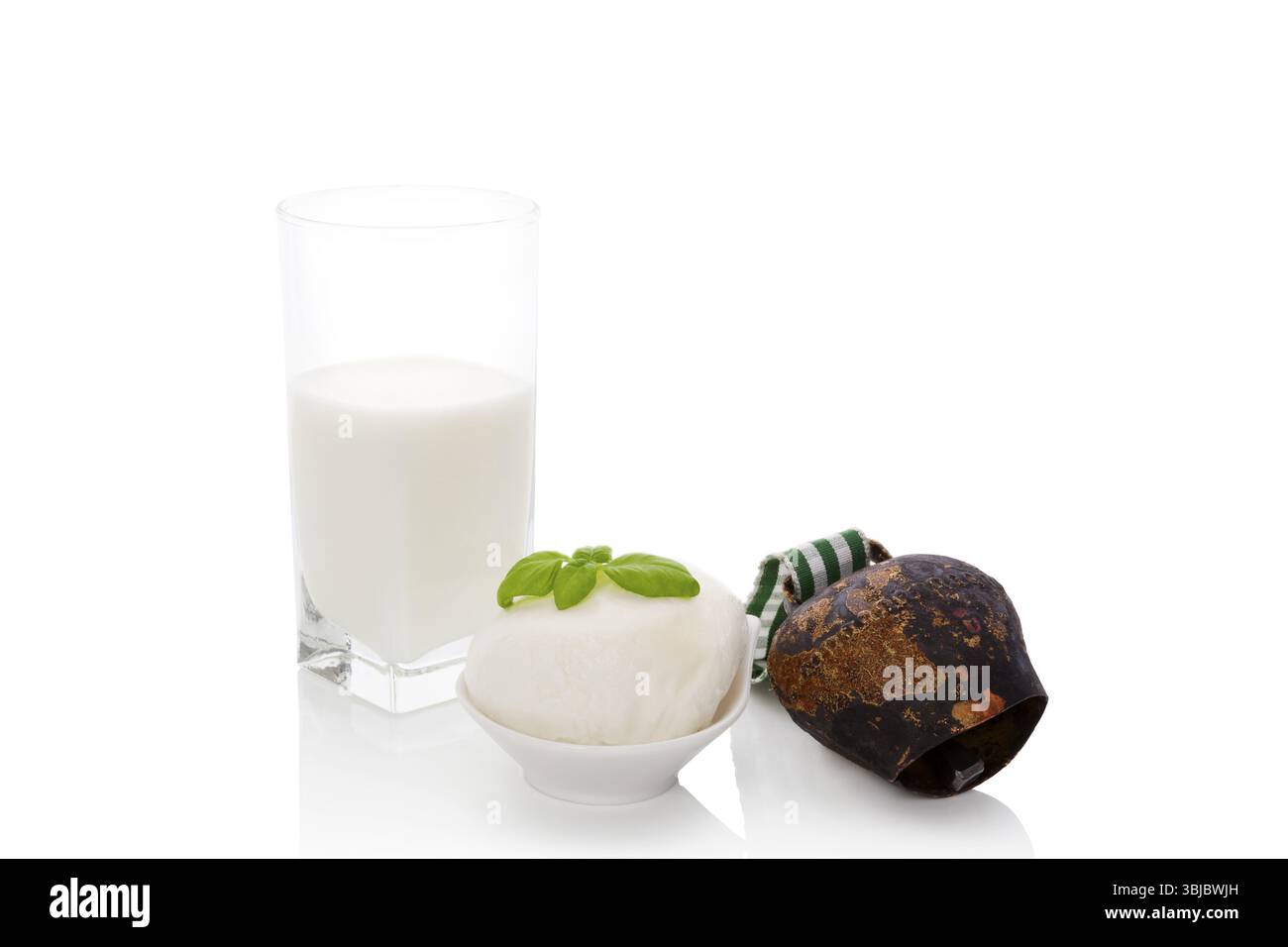 Hintergrund der Milchwirtschaft. Glas mit Milch, Mozzarella und Kuhglocke auf weißem Hintergrund. Traditionelle Milchprodukte Stockfoto