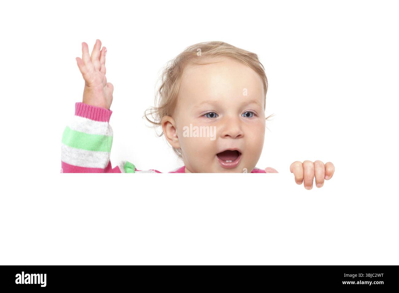 Erste Zähne. Niedliches Mädchen mit großen blauen Augen, offenem Mund mit zwei Zähnen, die über Weißtafel schauen und isoliert über weiß winken. Niedliches Baby Mädchen Conc Stockfoto