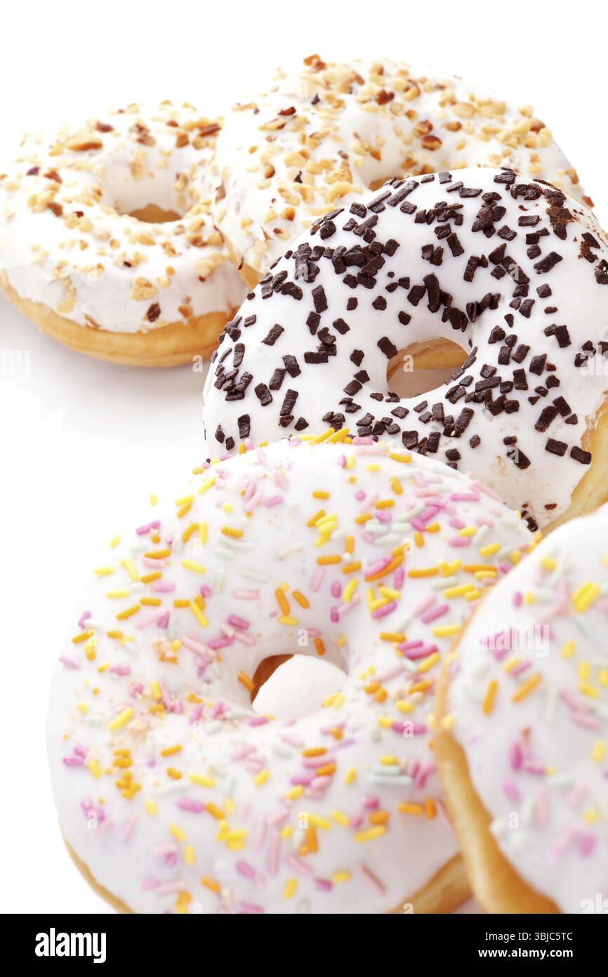 Verschiedene köstliche Donuts auf isoliert auf weißem Hintergrund. Süßes Frühstückskonzept Stockfoto
