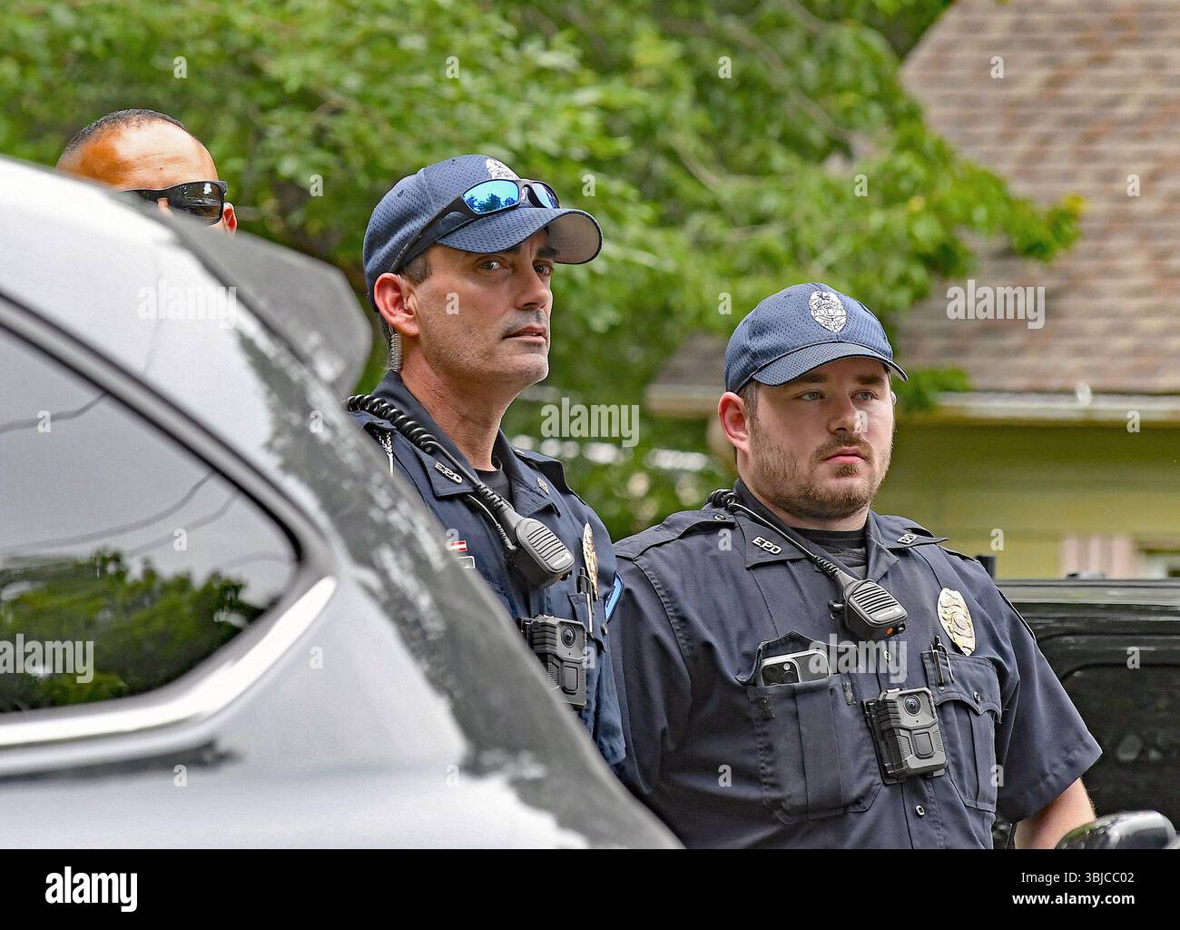 EMPORIA KANSAS, USA - 14. JUNI 2025 Mitglieder der örtlichen Polizeibehörde halten von der anderen Straßenseite aus nach Gegenprotestierenden beim No Kings Protest Ausschau. Stockfoto