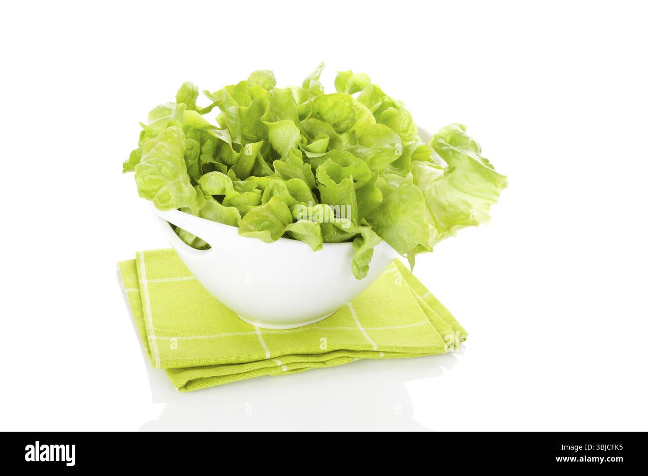 Frischer grüner Salat in weißer Schüssel isoliert auf weißem Hintergrund. Frische gesunde Sommeressen. Kulinarische Kunst. Moderne minimale Bildsprache Stockfoto
