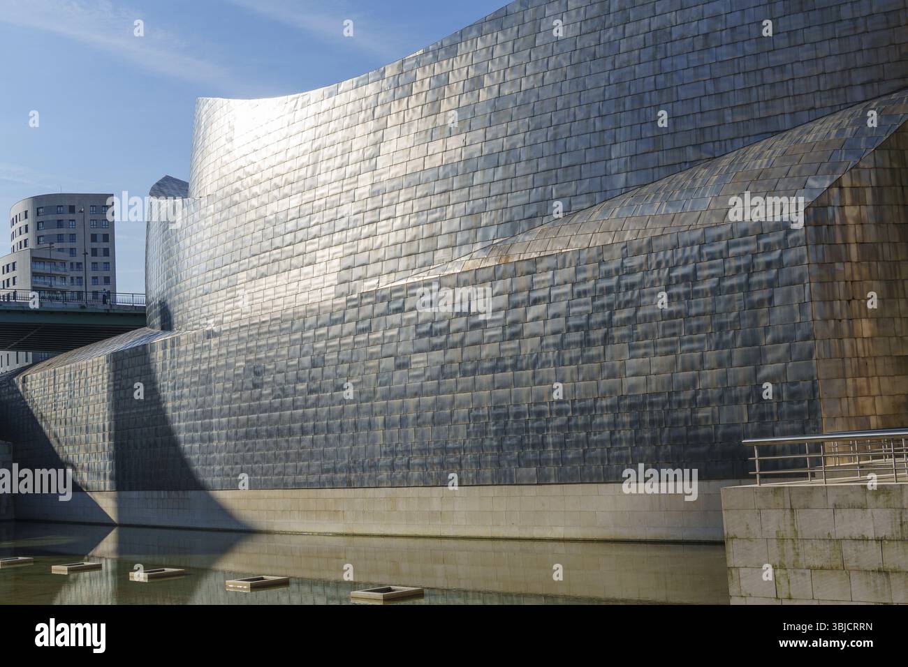 Metallfassade des Guggenheim Museums vor blauem Himmel und Wasser, Bilbao, Baskenland, Spanien, Europa Stockfoto